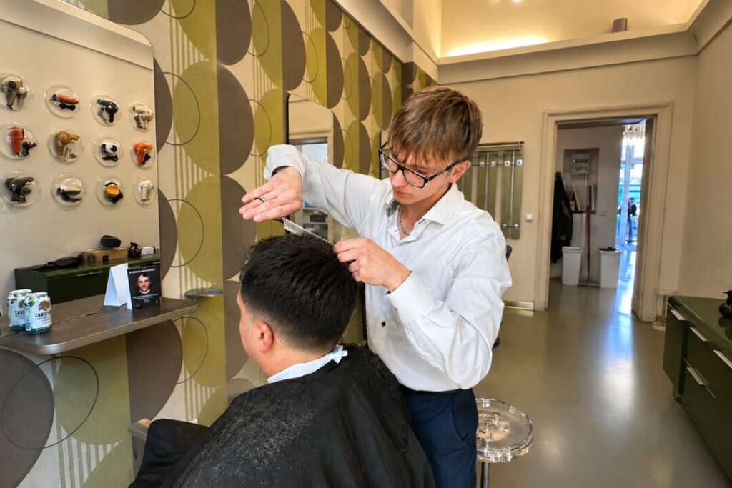 Friseur schneidet einem Kunden die Haare im Salon Haareszeiten in Berlin Prenzlauer Berg